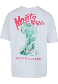Balts kokvilnas T-krekls ar krāsainu grafikas attēlu, kurā attēlots mojito, ar sarkaniem uzrakstiem "Mojito Magic" un "Cuban Classic" zem tā.
