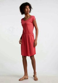 Czerwona sukienka krótki rękaw z elastycznym pasem, małymi bocznymi kieszeniami i białymi kropeczkami. Wykonana z lekkiego materiału.