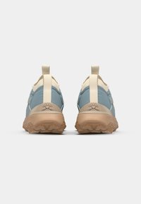 Blå og beige utendørs sko med strukturert gummisåle, polstret krage og doble pull-tabs for enkel påkledning.