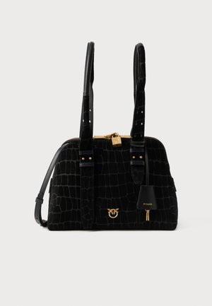 Crna torba od krokodilske kože s dvostrukim gornjim ručkama, zlatnom bravicom i logom, te odvojivim remenom za rame na bijeloj pozadini.