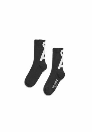 Paar schwarze Crew-Socken mit weißem, fettem Buchstaben „A“ und dem Schriftzug „ARREANGELS EST. 1932“ auf der Sohle, gerippte Struktur, flach auf weißem Hintergrund.