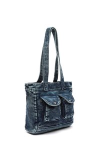 Jeans tote-väska med två framfickor, blå färg, två långa handtag och en något sliten textur. Har tryckknappar på fickorna.