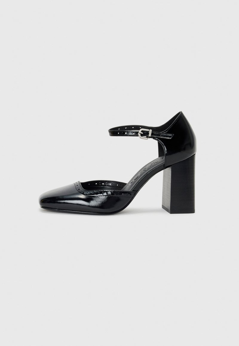 Schwarze patentierte Leder-High Heels mit quadratischer Zehenform, Knöchelriemchen und dicker Absatz. Enthält durchbrochene Details entlang des Randes.