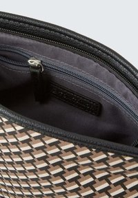 Texturierte, gemusterte Tasche mit einem geometrischen Design in erdigen Farbtönen. Verfügt über einen schwarzen Reißverschluss und ein glattes, dunkles Innenfutter.