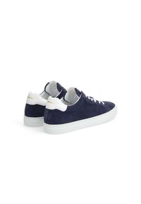 Navy suede sneakers with white accents, featuring a flat sole, round toe, and classic lace-up design. Gold branding on heels.