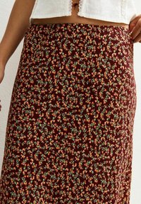 Bordeaux maxi rok met kleine oranje en groene bloemen. Lichte stof met een gladde textuur, ontworpen voor een comfortabele pasvorm.