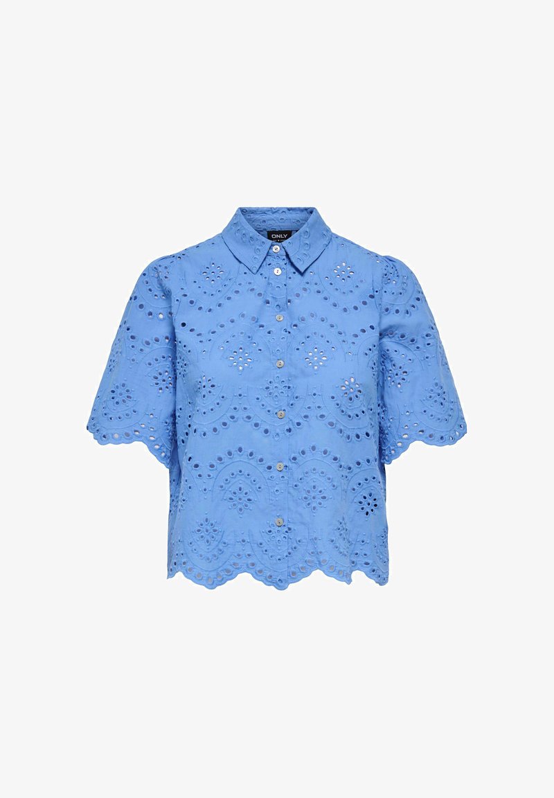 Blouse bleu clair à manches courtes avec bords festonnés, boutonnage frontal et détails de broderie florale ajourée sur le tissu.