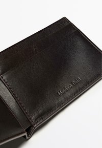 Mörkbrun läderplånbok med flera kortfack, en slät yta, diskreta söm detaljer och präglat märke.