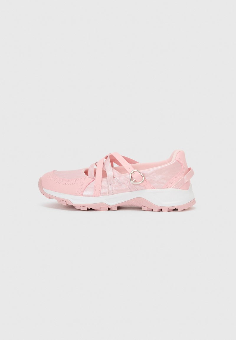 Pink athletic shoes with mesh and synthetic upper, featuring crisscross straps, heart-shaped hardware, and a textured white sole.