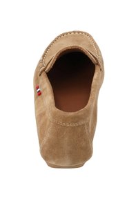 Beżowe zamszowe buty typu slip-on z okrągłym noskiem, przeszyciami oraz małym trójkolorowym akcentem przy pięcie. Wnętrze wykonane z brązowej skóry.