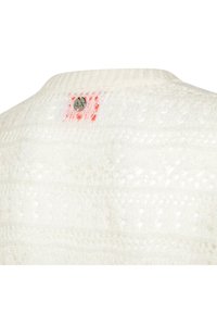 Maglione bianco lavorato a maglia con un delicato motivo in pizzo, scollatura rotonda e una piccola etichetta con logo con accenti rossi sul retro.