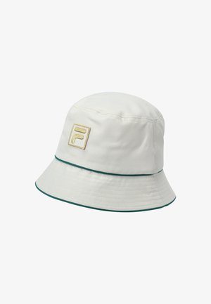 Crèmekleurige bucket hat gemaakt van stof, met een groene rand en een gouden geborduurd logo aan de voorkant. Smooth textuur en ronde vorm.