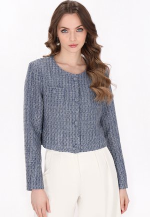 Jachetă scurtă din tweed albastru cu un model texturat, guler rotund, două buzunare frontale și închidere cu nasture. Mâneci lungi și croială structurată.