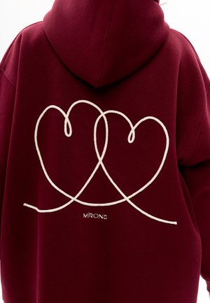 Burgundy hoodie with a white embroidered heart design on the back. Features a large hood and soft texture. "MIRONS" logo at the bottom.
