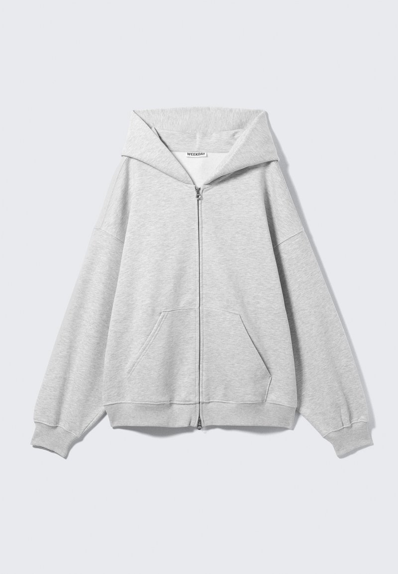Felpa grigia con zip, ampia cappuccio, vestibilità oversize, tasca a marsupio, polsini e orlo a coste. Realizzata in morbido tessuto di cotone testurizzato.
