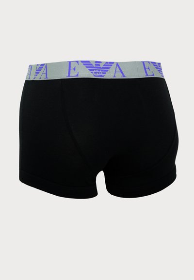 Schwarze Boxershorts mit glatter Textur, ausgestattet mit einem grauen Bündchen, das mit lila Branding bedruckt ist. Klassische Passform mit weichen Nähten.