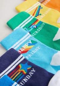 Multicolored ankle socks featuring different designs for each day of the week, with stripes and cheerful patterns. Made from soft cotton material.