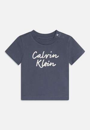 Granatowy, krótki rękaw, niemowlęca koszulka z białym napisem „Calvin Klein” z przodu i zatrzaskami na lewym ramieniu.