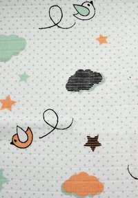 Baumwollstoff mit verspielten Drucken von Vögeln, Wolken und Sternen in Orange, Grün und Schwarz auf einem weißen gepunkteten Hintergrund.