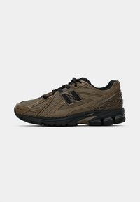 Brown running shoe with textured mesh upper, black accents, and cushioned sole. Features a lacing system and streamlined design.