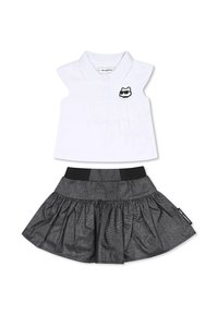 Ensemble deux pièces comprenant une chemise polo blanche avec un devant plissé et un logo de chat noir, assortie d'une jupe noire évasée avec une taille élastique.