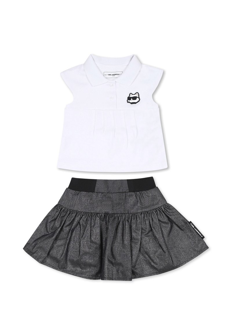 Ensemble deux pièces comprenant une chemise polo blanche avec un devant plissé et un logo de chat noir, assortie d'une jupe noire évasée avec une taille élastique.