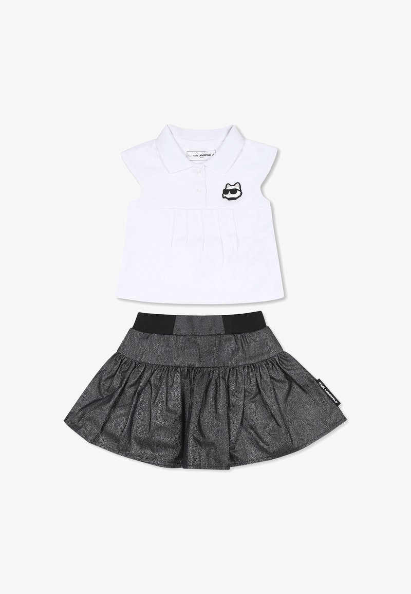 Ensemble deux pièces comprenant une chemise polo blanche avec un devant plissé et un logo de chat noir, assortie d'une jupe noire évasée avec une taille élastique.
