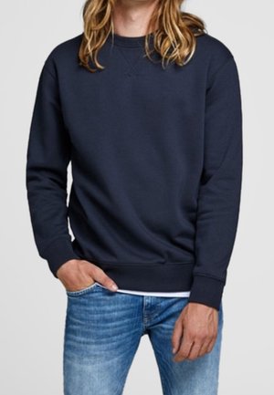 Mörkblå sweatshirt i bomull, med klassisk rund halsringning, ribbade ärmslut och avslappnad passform, i kombination med ljusblå jeans.
