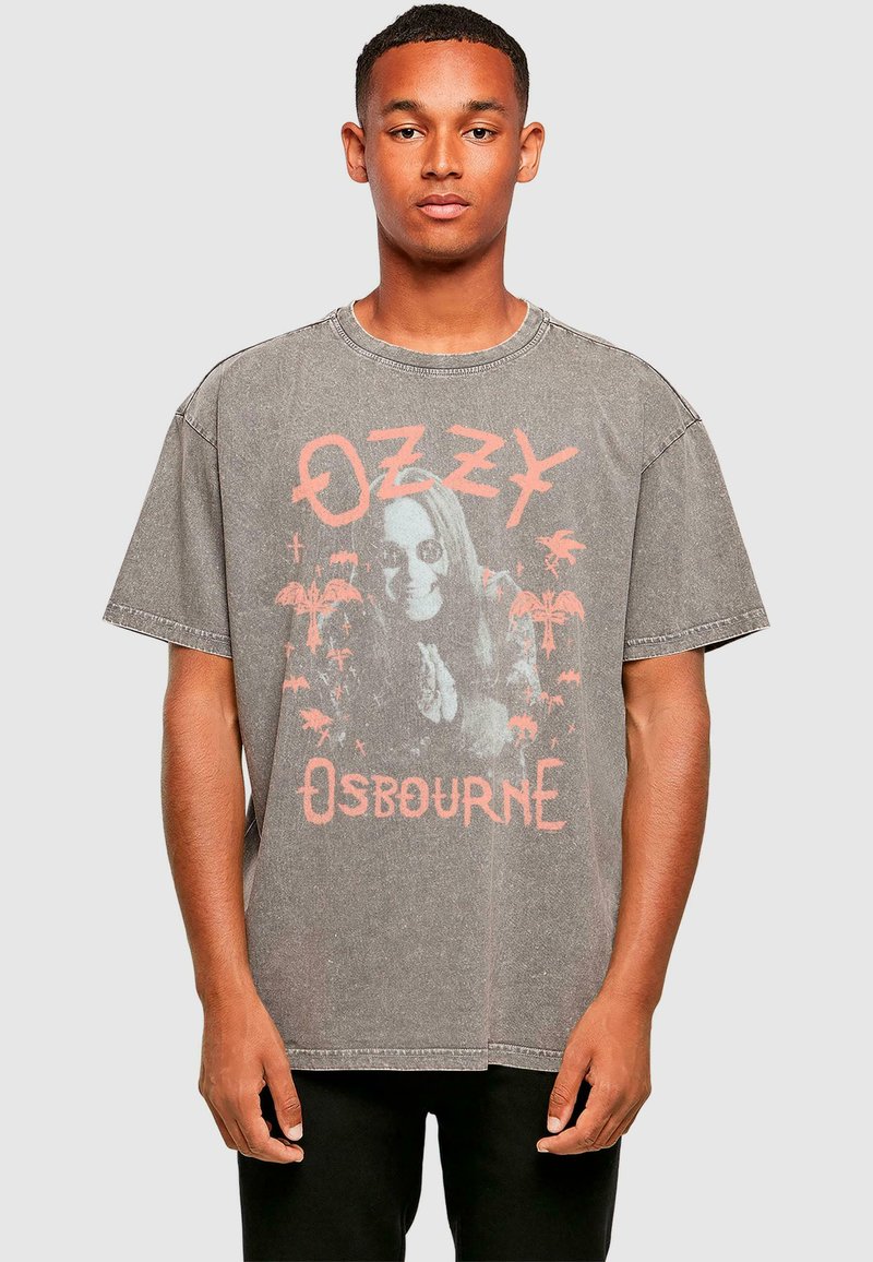 Tricou supradimensionat gri, din bumbac, având un grafic estompat cu o figură cu păr lung, palmieri și numele "Ozzy Osbourne" în text roz.