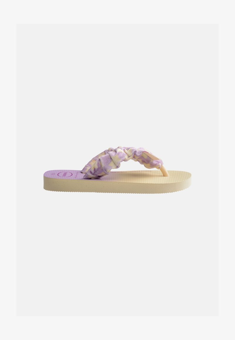 Beige flip-flop sandal with textured sole and soft, twisted straps in a purple and yellow tie-dye pattern.