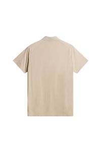 Beige pikétröja med korta ärmar, med ett strukturerat mönster och en slät krage. Designad för en avslappnad passform med raglanärmar.