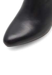 Czarny skórzany botek za kostkę z wąskim noskiem, gładką fakturą i minimalistycznym designem. Smukła sylwetka, brak widocznych elementów metalowych lub akcentów.
