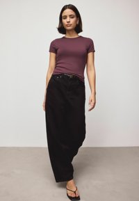 Bordo prigludusi marškinėliai, juodos aukšto liemens džinsinės kelnės, lygi tekstūra, plačios kelnės, klasikinis penkių kišenių dizainas, juodos sandalai.