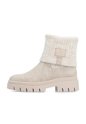 Beige ankle boot with thick tread sole, fold-over knit cuff, and stitched logo patch on outer side.