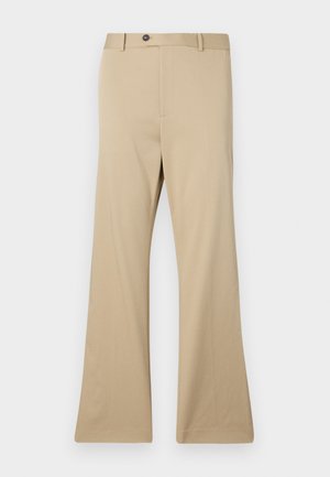 Pantalons évasés beiges en tissu lisse. Dotés d'une fermeture à bouton, de poches avant et d'une coupe ajustée au niveau des hanches, s'élargissant vers une jambe large.
