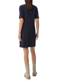Marineblaues kurzärmliges Kleid mit geradem Schnitt und Rückennaht. Kombiniert mit hellbeigen knielangen Stiefeln, Gummisohle und elastischen Akzenten.