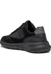 Black athletic shoe featuring a mix of smooth and suede textures, a padded collar, and a textured rubber sole with visible tread patterns.