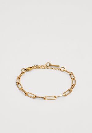 Aukso metalo grandinėlių apyrankė, pasižyminti pailgomis jungtimis ir krabų tipo užsegimu, su reguliuojama grandinės prailginimo dalimi, leidžiančia pritaikyti dydį.