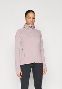 Sweatshirt rosa claro com fecho de correr e gola alta, com buracos para os dedos nos punhos e um detalhe subtil de logótipo na lateral, feito de tecido macio.