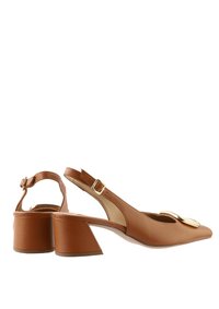 Brązowy skórzany but typu slingback z szpiczastym noskiem i grubym obcasem. Posiada metaliczny akcent na nosku oraz regulowany pasek z klamrą.