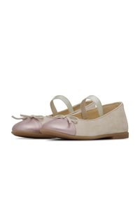 Bailarinas con un suave cuerpo de ante beige, puntera en brillante oro rosado y dos correas elásticas. Presentan un detalle de lazo en la punta.