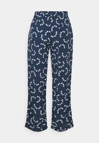 Calças azul-marinho com estampa floral branca, apresentando um corte descontraído, cintura elástica e um único bolso traseiro. Textura de tecido suave.