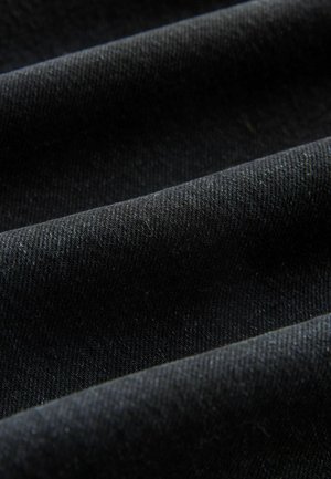 Black denim fabric with a smooth texture, featuring visible diagonal weave patterns and subtle variations in shading from folds.