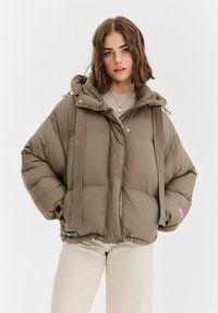 Khakiowa kurtka puchowa z kapturem, o pudełkowatym kroju, z poziomą pikowaną fakturą i kontrastującym różowym logo na rękawie.