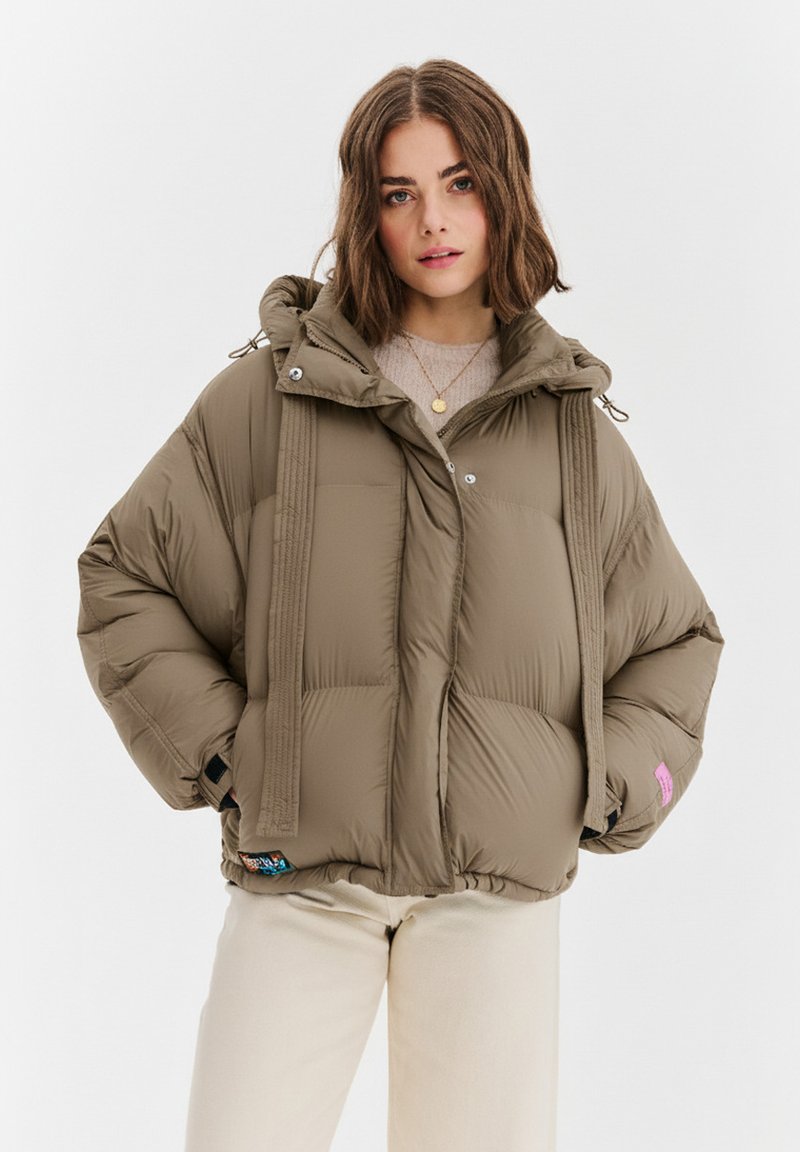 Khakiowa kurtka puchowa z kapturem, o pudełkowatym kroju, z poziomą pikowaną fakturą i kontrastującym różowym logo na rękawie.