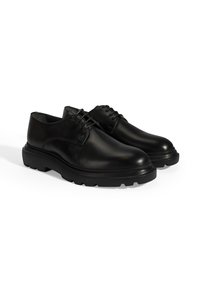 Schwarze Leder-Schnürschuhe mit einer abgerundeten Spitze, dicker Gummisohle und sichtbaren Nähten im Obermaterial. Glatte Textur über die gesamte Oberfläche.