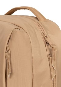 Zaino beige con una texture del tessuto liscia, doppie cerniere e una maniglia superiore. Design compatto con dettagli di cucitura rinforzati.