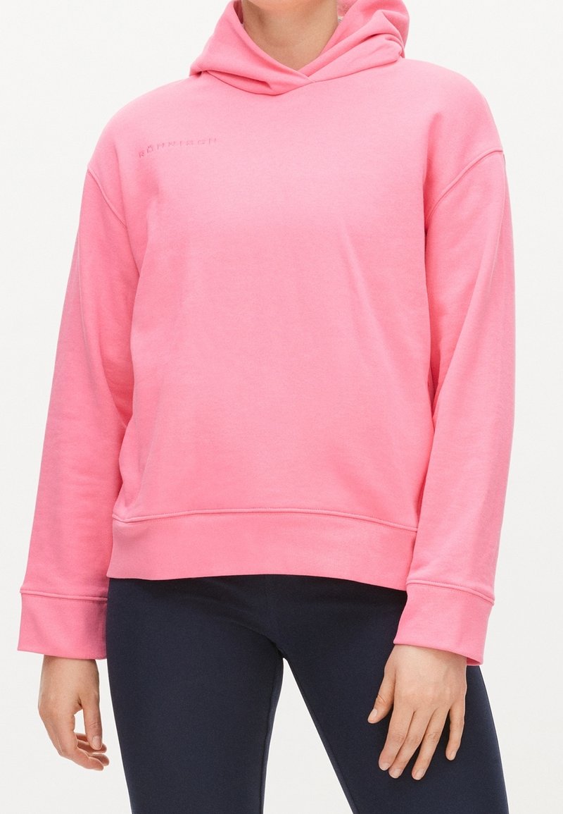Růžová bavlněná mikina s volným střihem, velkou kapucí, žebrovanými manžetami a značkovým logem na hrudi. Hladká textura a neformální design.