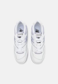 Ein Paar weiße und helllila New Balance 550 Sneaker mit weißen Schnüren, von oben auf einem weißen Hintergrund betrachtet.