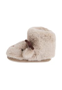 Luddig beige toffel med rund form, som har en plyschliknande textur, dekorativa bruna accenter och en mjuk sula.